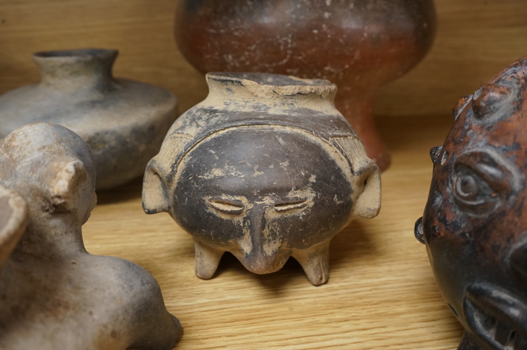 A collection of various South American vessels some in the form of grotesque heads, largest 24cm wide